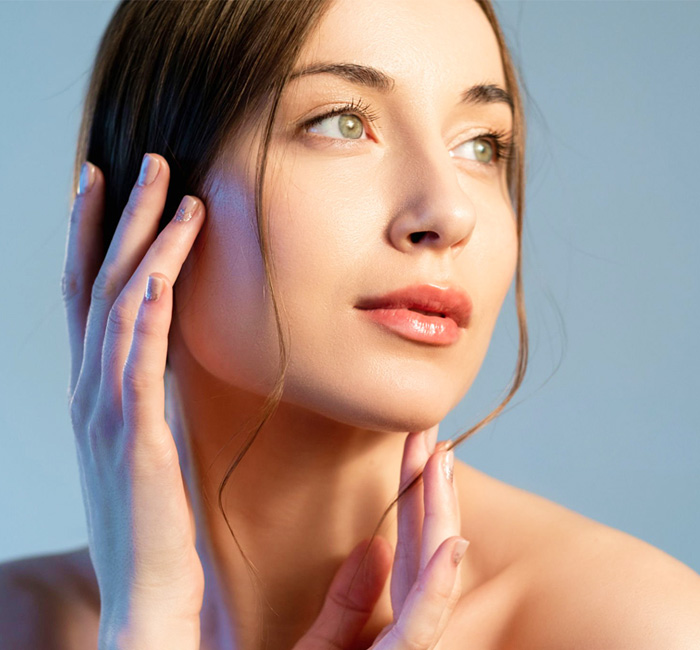 Woman with nude makeup touching flawless radiant face